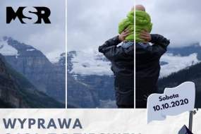 Ojciec z dzieckiem patrzący na góry; tekst: wyprawa 10.10.2020