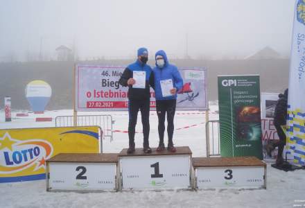 Podium Mistrzostw Polski Amatorów kategoria M60: miejsce 1.Porębski Piotr, miejsce 3. Mucha Edward; w tle baner imprezy i banery sponsorów