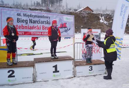 Dekoracja najmłodszych dziewcząt, na podium kolejno Partyka Lena, Michałek Oliwia i na miejscu trzecim Legierska Milena; dyplomy wręcza Łucja Dusek – Dyrektor Gminnego Ośrodka Kultury