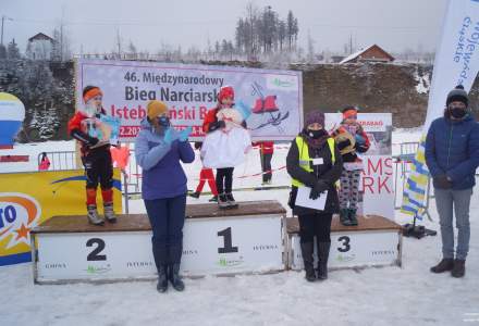 Dekoracja najmłodszych dziewcząt, na podium kolejno Partyka Lena, Michałek Oliwia i na miejscu trzecim Legierska Milena; w rękach Leny Partyki kabotek; na zdjęciu widoczna Wójt Gminy Istebna – Łucja Michałek, Dyrektor Gminnego Ośrodka Kultury Łucja Dusek