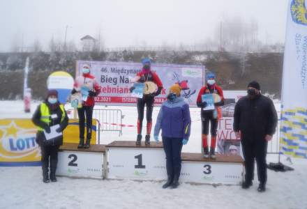 Dziewczęta z kategorii V-VI klasa na podium: na miejscu 1. Gazurek Kinga, na 2. Kohut Zuzanna, a na 3. Haratyk Noemi z dyplomami i statuetkami; wręczający nagrody Wójt Gminy Istebna Łucja Michałek, Dyrektor Gminnego Ośrodka Kultury Łucja Dusek i J. Kędzio