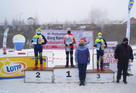 Chłopcy z kategorii V-VI klasa na podium: na miejscu 1. Juroszek Filip, na 2. Kroutil Simon, a na 3. Vinohradnik Jan z dyplomami , nagrodami i statuetkami; wręczający nagrody Wójt Gminy Istebna Łucja Michałek oraz radny sołecki Jerzy Kędzior