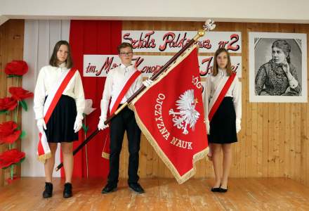 Szkolny Poczet Sztandarowy ze sztandarem, na czerwonym tle biały orzeł