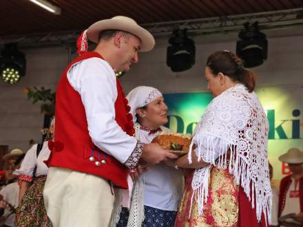 Wójt Gminy Istebna Łucja Michałek przyjmuje chleb dożynkowy od gazdów dożynkowych z Koniakowa Małgorzaty i Józefa Juroszków