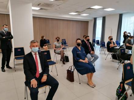 Uczestnicy konferencji siedzący na krzesłach podczas podpisania umowy na dofinansowanie tras na Kubalonce.
