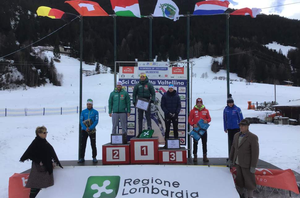 Dominik Bury na podium zawodów (w czerwonej kurtce)